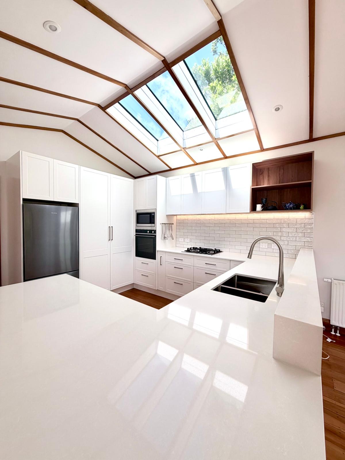Kitchen renovation with timber-framed skylights and stone benchtop