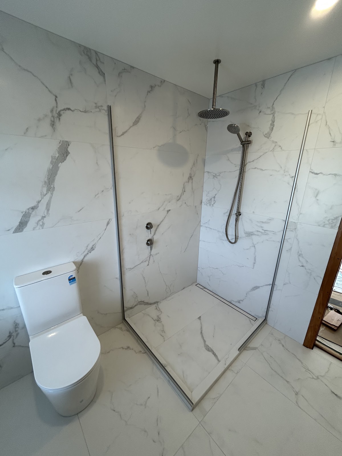 Walk-in marble tiled shower with rain head